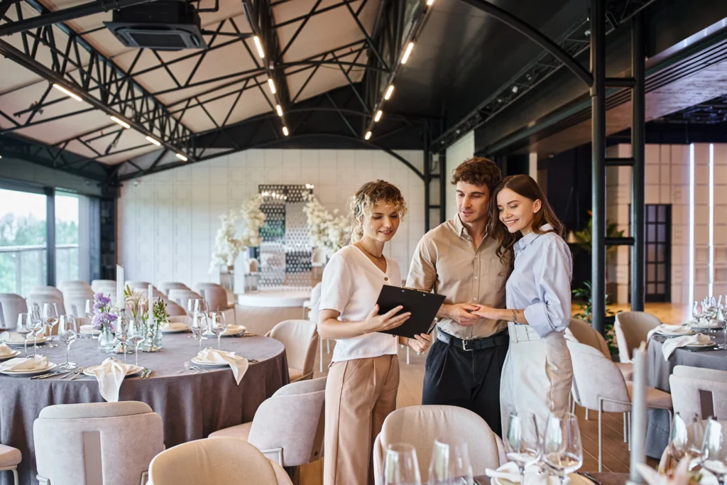 Un couple réserve sa salle du mariage : il peut donc ainsi commencer à chercher un vidéaste de mariage